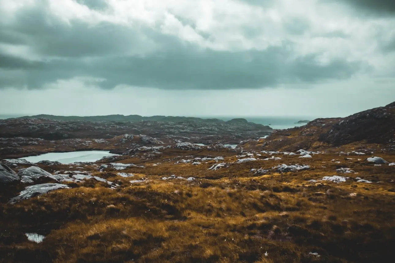 Wide Highland moorland and lochans beneath heavy cloud